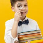 boy holding stack books